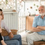 Family gathered indoors, engaged in conversation with a focus on bonds and togetherness.