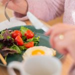 Enjoy a nutritious breakfast with greens, fried egg, and fresh orange juice for a healthy start to your day.