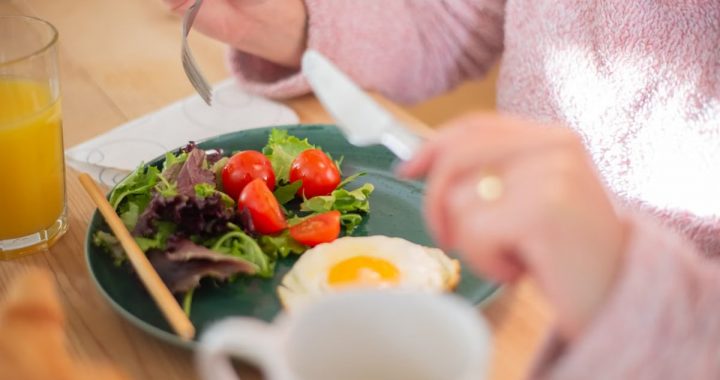 Enjoy a nutritious breakfast with greens, fried egg, and fresh orange juice for a healthy start to your day.