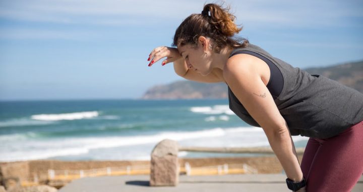 A woman rests after exercise, overlooking the ocean in Portugal's scenic seascape.